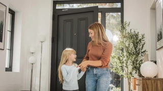 Mutter mit Tochter im Eingang des Hauses.